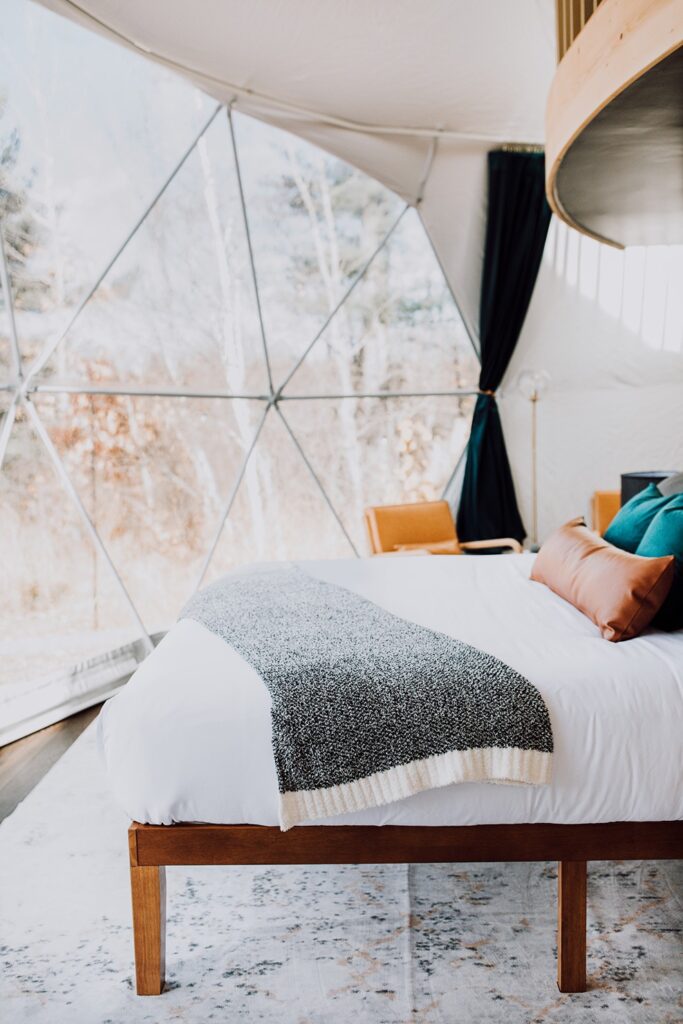 Cozy King Bed overlooking private prairie view through the 20 foot bay window in Basalt dome at Sweetbriar Ridge